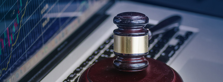 wooden gavel sitting on laptop keyboard