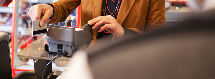 female swiping credit card at a store checkout