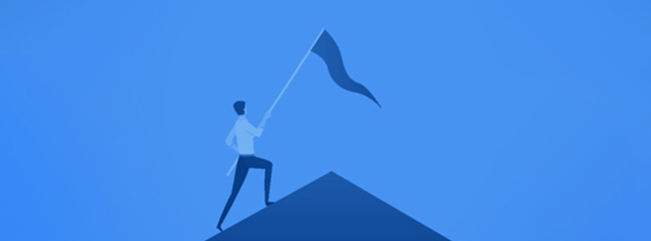 man sticking a flag into a mountain peak