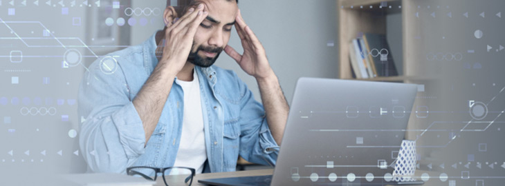 frustrated businessman looking at spreadsheets on his laptop computer