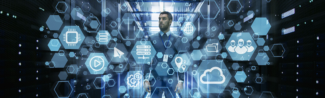 IT Engineer standing in the middle of a working data center server room with cloud and internet icon visualization in the foreground